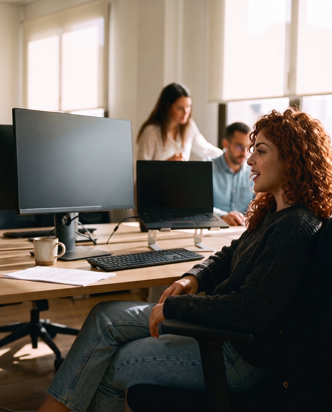 Lisa lehnt sich im Großraumbüro zurück und diktiert eine Mail an ihren Computer.